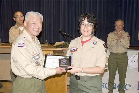 Peter Wang (left) presents the District Award of Merit to Helen Young.