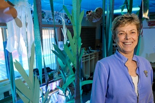 Teacher Susan Pynchon stands among the crepe-paper kelp for an aquarium-theme display in her classroom at Kelsey Creek Homeschool in Bellevue on Friday