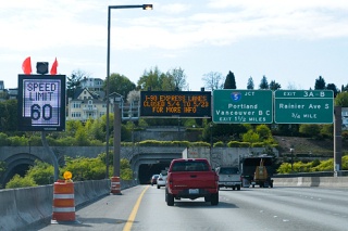 A sign warns drivers of work to repair expansion joints on the I-90 bridge while another tells drivers what the speed limit is because of traffic.