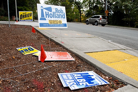 Damaged campaign signs are strewn along Forest Drive Southeast near Somerset Drvie Southeast in Bellevue on Monday. Someone sliced through many of the signs with what appeard to be a knife. Election season often finds candidates’ signs damaged. This year is no exception.