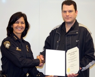 Bellevue Police Chief Linda Pillo congratulates Kirkland resident Kristopher Beal on his courageous act of bringing down a bank robber during a heist.