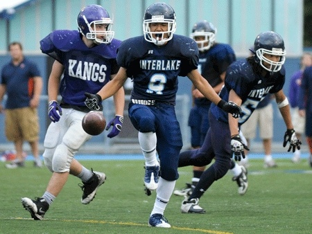 Genki Kawashima (center) celebrates an interception against Lake Washington during the Interlake spring football jamboree on June 19.