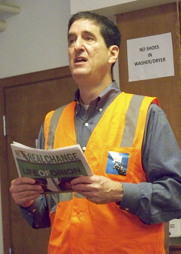 Real Change managing director Alan Preston addresses a group of  men about selling papers at the Congregations for the Homeless Day Center in Bellevue on Monday.