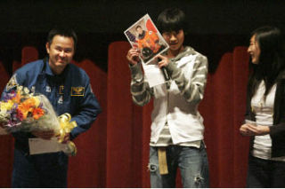Japanese astronaut Akihiko Hoshide bows as Kojiro Narita and Momoka Nakamura show off the signed autograph to the audience after a presentation about Hoshide’s recent trip to the International Space Station. Hoshide met with students at the Sammamish High School theater on Saturday