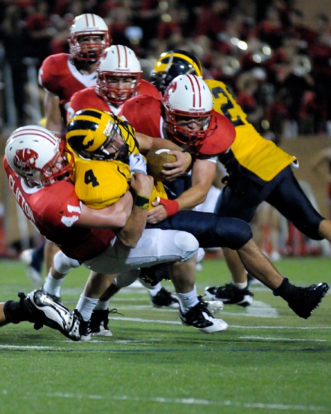 Wolverines RB Sean Coley (4) is tackled by Tigers LB Grant Clifton (41) in a 35-17 loss to Katy in Texas on Saturday night.