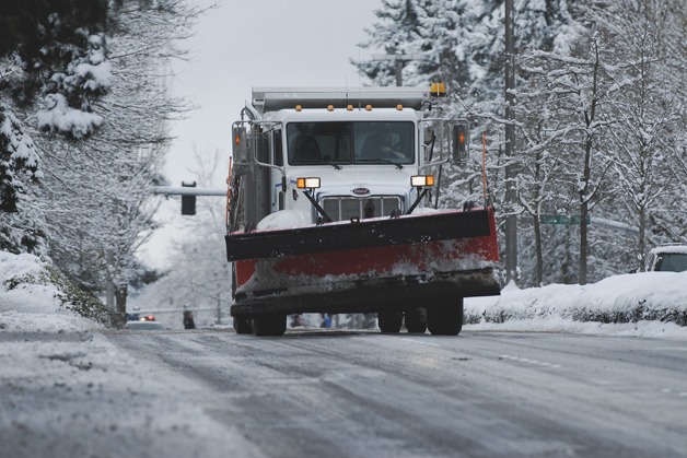 A snow plow works to clear up roads during a snowfall in February.
