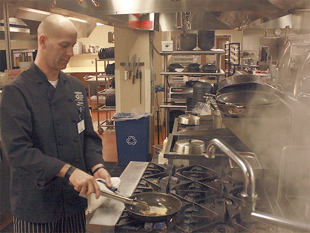 Chris Linaman prepares a cut of salmon in Overlake Medical Center’s kitchen. The executive chef has worked to increase the kitchen’s usage of antibiotic-free meat