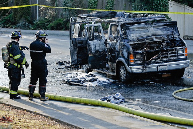 Fire investigators photograph the scene of a vehicle fire in the 1600 block of Kamber Road in Bellevue on Wednesday. Three people in the van were burned and sent to Harborview Medical Center in Seattle.