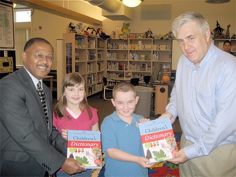 Bellevue Overlake Rotarians Clarence Cal (left) and Mick Repanich (right) present dictionaries to Phantom Lake third-graders Camille Larson and Patrick Mahoney on Tuesday.