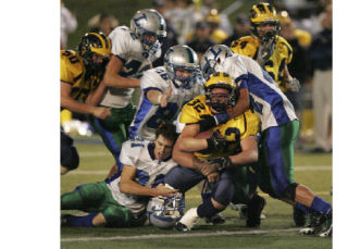 Bellevue senior running back Eric Nelson gets surronded by Liberty defensive players during Bellevue’s 24-7 win over the Patriots. The Wolverines clinched the KingCo 3A conference title with the homecoming win in Bellevue.