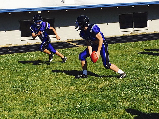 Bellevue Christian quarterback David Postma pitches the ball to a teammate during a practice session on June 22 at Bellevue Christian High School.