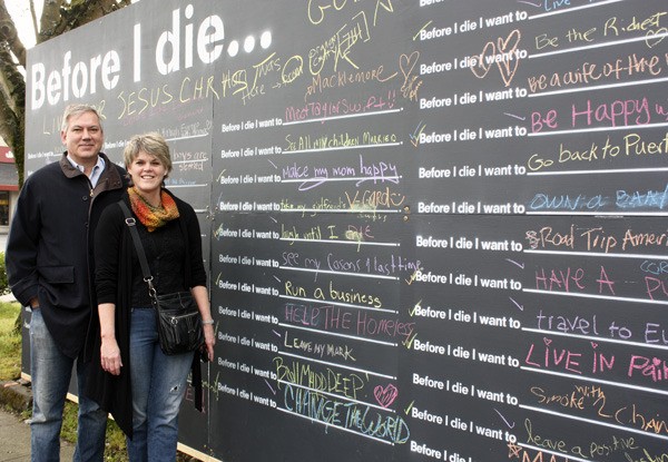 Paul and Patty Gordon show the ‘Before I Die’ wall they created at Bellevue Way and Main Street. Similar walls have been put in in Kazakhstan