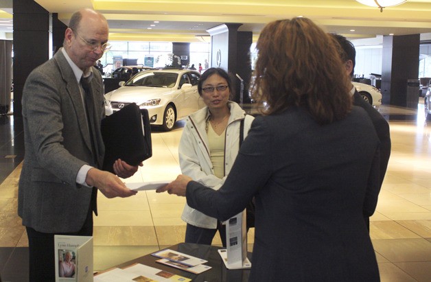Bruce Arbtin hands off a resume to representatives of New York Life Insurance at the Bellevue Chamber of Commerce Job Fair Tuesday.