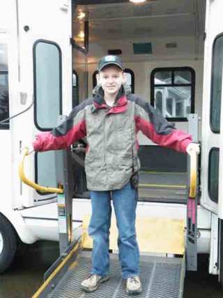 Connor Burshears stands on the lift ramp of a wheelchair accessible bus. The 11-year-old raised money for two of the vehicles. His goal is to provide a fleet of such vehicles.