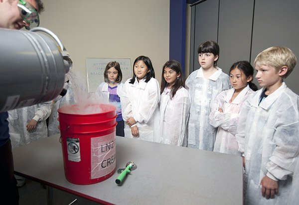 Camp-goers observe an experiment as part of the Pacific Science Center’s Curious Minds summer program.