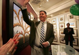 Artist Robert Deber waves to people gathered for his exhibit's opening day at Martin Lawrence Gallery in Bellevue Square on Wednesday