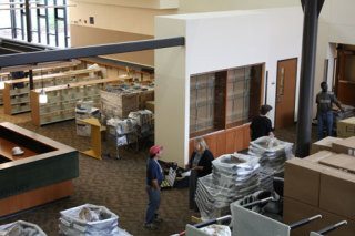 Sherwood Forest Elementary School principal Gail McDonald (center) talks with head custodian Xuan Cao as furnishings begin to arrive at the new school.  In the rear left is the school’s new library.