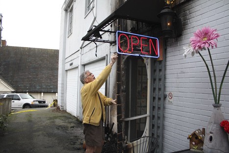 Dave Paup turns on the open sign at Cookies in Bloom