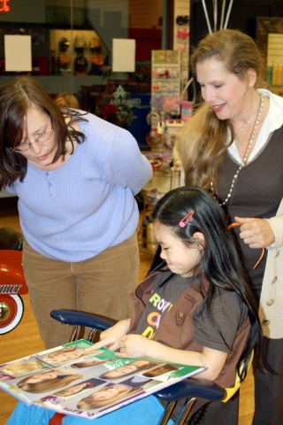 Carina Ableman checks out a new hair style she will get after donating much of her hair to the Locks of Love Foundation.