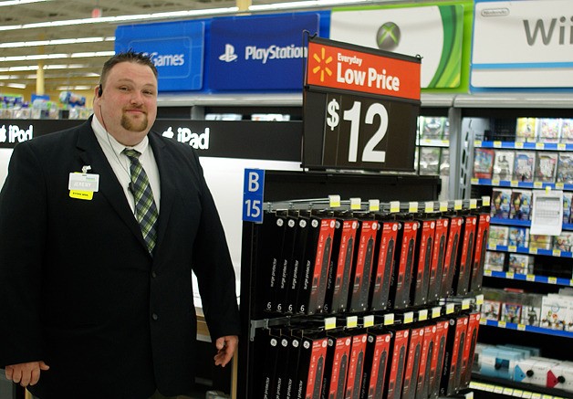 Walmart store Manager Jeremy Winn stands by a display of iPods and iPads