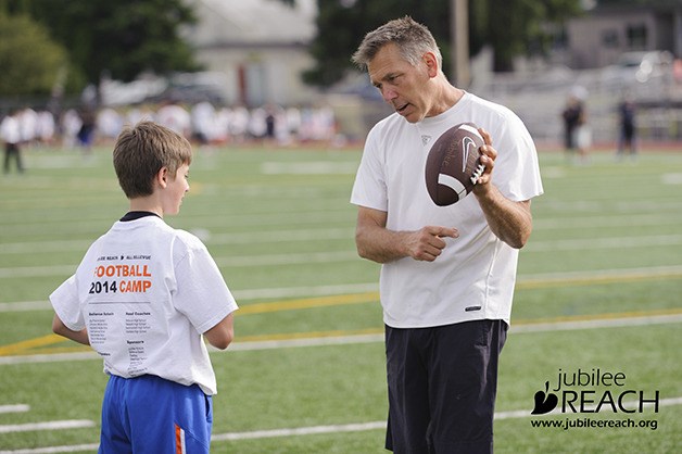 Jim Zorn talks with a youngster at the free Jubilee REACH football camp