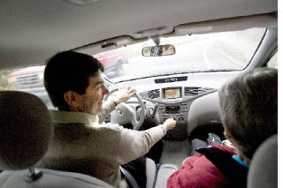 Phil Slater visits with Dorothea Benedict of Bellevue as he adjusts the heat in the car. Slater is a volunteer driver who was taking Benedict to a doctor’s appointment.