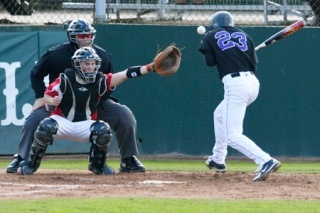 Lake Washington's Spencer Wozeniak is hit by Newport's Jared Fisher during the Kang's 10-5 win at Bellevue College on Wednesday.