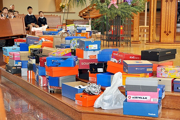 Students at Sacred Heart Parish School in Bellevue look at some of the shoes donated as part of the school's annual 'Shoe Liturgy.'' More than 350 pairs of shoes were collected by all students in grades PreK-8 and given to Treehouse to help foster children.