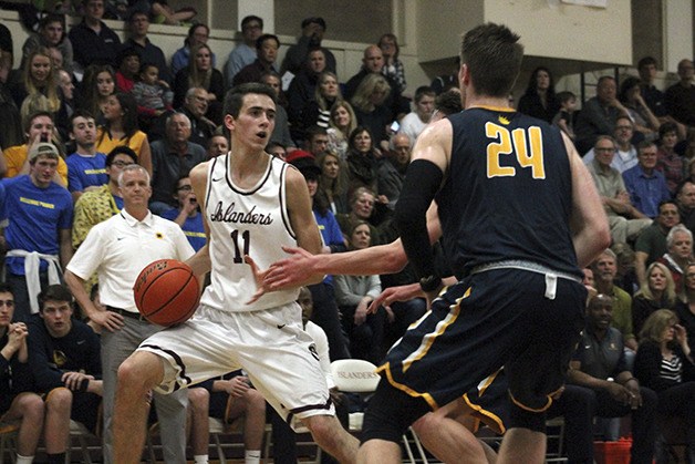 Mercer Island's Sam Nordale (11) evades Bellevue defenders Colin Suter and Mikey Henn in the regular season finale on Feb. 5. The Wolverines defeated the Islanders 58-47.