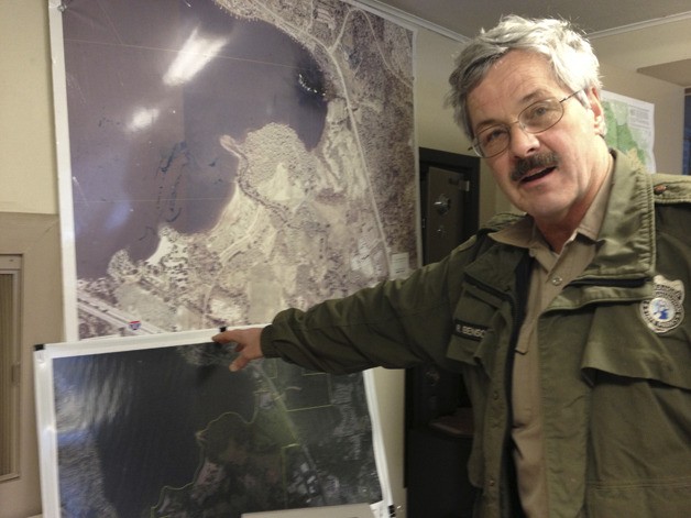 Park Ranger Rich Benson points out the location of the baseball fields on a map of the park.