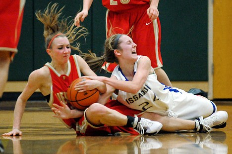 Knights guard Caitlin Bennett (20) and Eagles guard Blaire Brady (24) hit the floor for a loose ball during a game played at Eastlake High School on Friday. Issaquah won 56-34 handing Newport their first loss of the season.