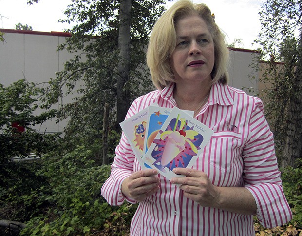 Gail Round holds up a few of her favorite card designs.  After 35 years in business