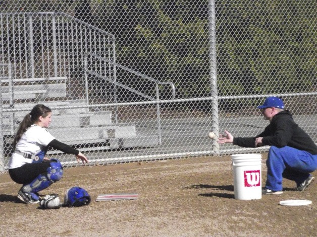 BCS coach Ryan Kelly works with catcher Ali King during practice