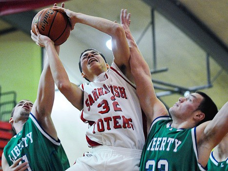 Totems George Valle (32) is fouled by Liberty defenders on a drive to the basket during Kingco 3A league tournament play at Sammamish on Tuesday.
