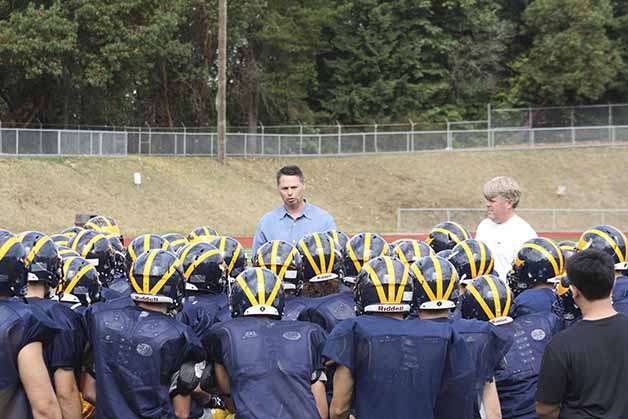 Head coach Butch Goncharoff (left) and coach Pat Jones address the team after a fall practice.