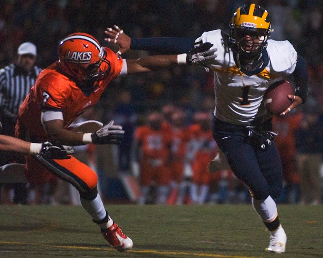 Wolverine QB Tyler Hasty (1) breaks free from Lancer DB Cedric Dozier (7) for a touchdown run during a 3A playoff quarterfinal game at Harry Lang Stadium in Lakewood on Friday. Bellevue beat Lakes 35-14.