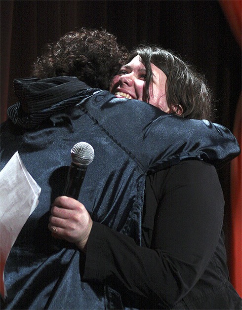 High school senior Julianna hugs emcee Meeghan Black after sharing her YES success story.