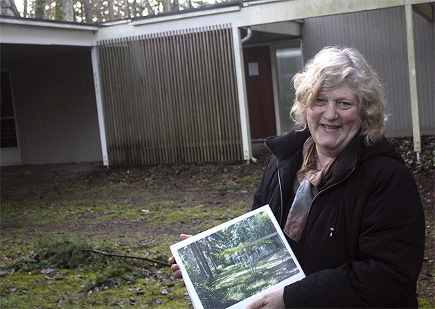 Newport Hills Community Club member Robin Bentley stands in front of a mid-century home designed by Northwest architect Paul Hayden Kirk. The club wants the city to buy the home and property at auction for a park