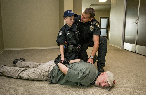 Gage Hancock-Stevens handcuffs 'bad guy' Lieutenant Kleinknecht as part of a mock burglary on Saturday