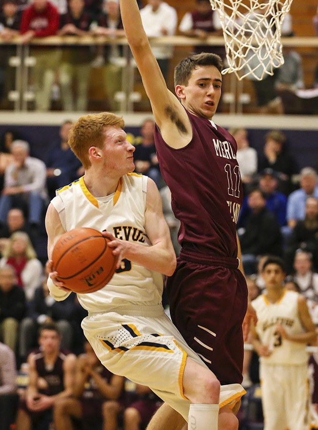Bellevue Wolverines senior point guard Kyle Foreman drives to the hoop while being guarded by Mercer Island's Sam Nordale in the first half of play.
