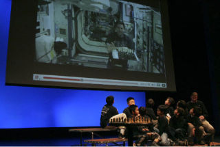 Stevenson Elementary students look at the screen that plays a recorded message from American astronaut Dr. Gregg Chamitoff aboard the International Space Station during an event at Bellevue Community College.