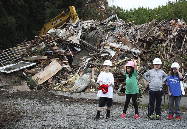 Children stand in front of the construction site of the new Downtown Bellevue clubhouse.