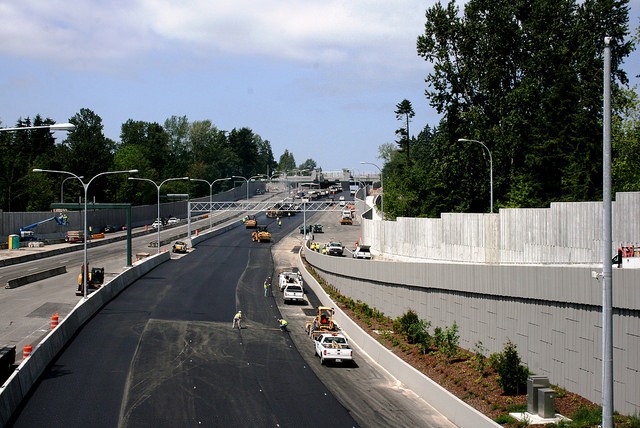 Crews work along the closed SR 520 highway place thousands of tons of fresh asphalt on the westbound lanes June 1. The roadway will be closed this weekend between Montlake Boulevard and Interstate 405 as crews pour concrete and place asphalt along the eastbound route.