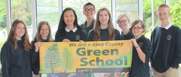 Students at Sacred Heart School in Bellevue show off a banner signifying that the school became part of the King County Green School program. The student council worked to reduce campus paper use