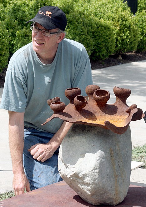 David Eisenhour works at installing his sculpture 'Lichen Horn' at City Hall Pavillion on Thursday