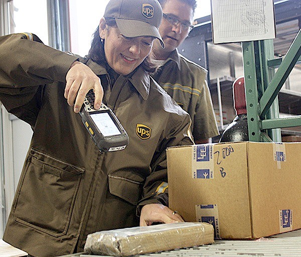 Congresswoman Suzan DelBene scans a package while UPS delivery driver Mike Vallimont watches on Wednesday morning at Triumph Aerospace Group on Redmond Ridge. DelBene