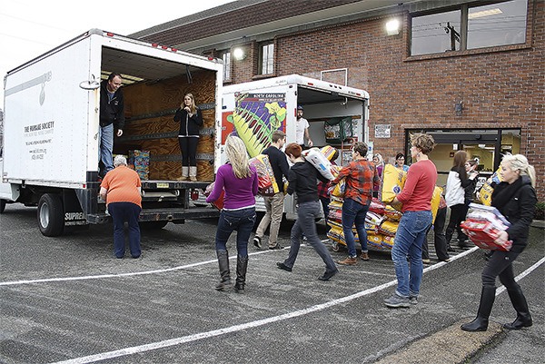 Volunteers from pet insurance company Trupanion help load the nearly four tons of pet food donations they collected for the Seattle Humane Society.