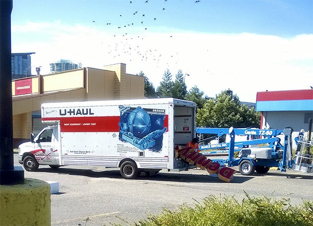 The Denny's sign at the restaurant on 116th Avenue Northeast is loaded into a U-Haul truck. The restaurant closed three weeks ago