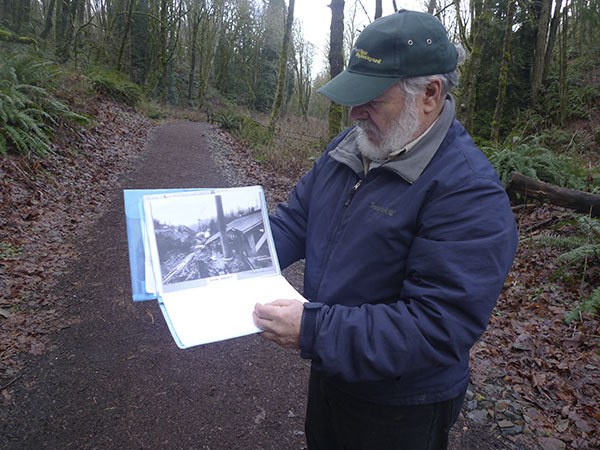 Steve Williams aligns an old photograph of the Newcastle mines with a trailhead along Cougar Mt.