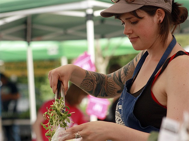 A Bellevue Farmers Market vendor fills an order during the 2014 season in May.